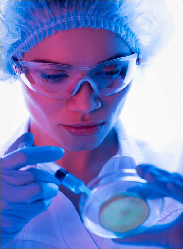 Investigadora en laboratorio manipulando una placa de Petri con una pipeta.