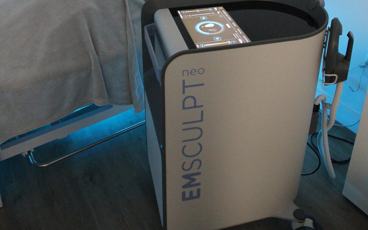 Equipo EMSCULPT NEO junto a la camilla, en una cabina de Clínica Bioever
